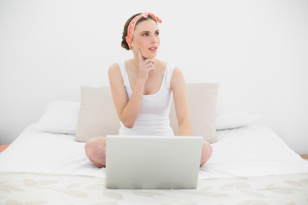 Mujer que trabaja con su cuaderno mirando hacia arriba