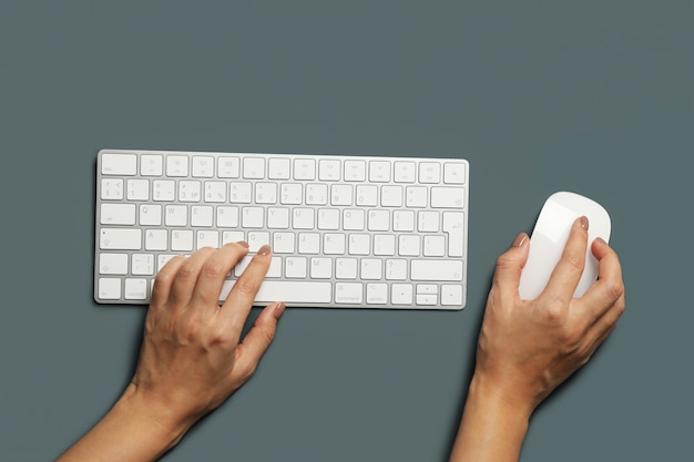 Mujer que trabaja en el teclado moderno sobre fondo oscuro