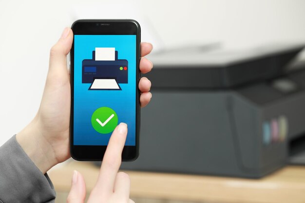 Foto mujer que usa la aplicación de administración de impresoras en el primer plano de un teléfono inteligente en interiores y espacio para texto imagen en la pantalla del dispositivo