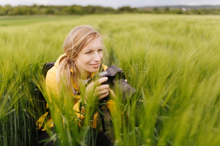 Mujer que usa una cámara digital para hacer fotos al aire libre