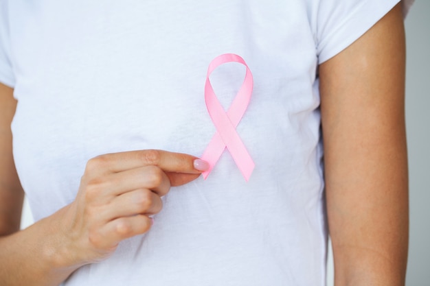 Mujer que usa cinta rosa para apoyar la causa del cáncer de mama o el SIDA.