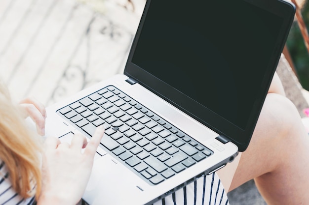 Mujer que usa la computadora portátil fuera de la oficina.