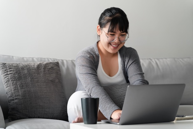 Mujer que usa una computadora portátil que trabaja en la oficina en casa o en el lugar de trabajoxA