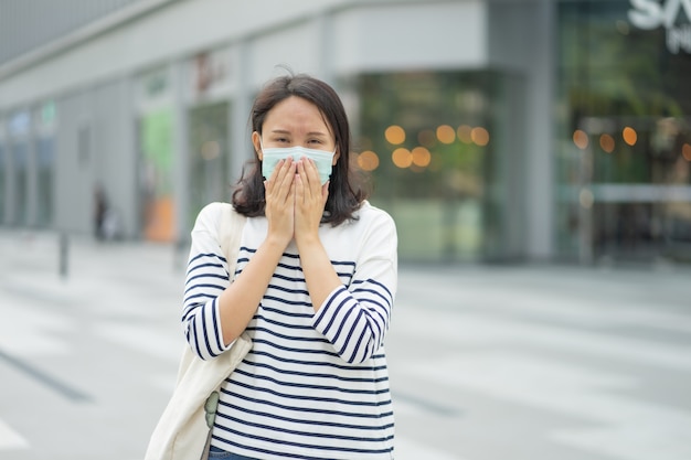 La mujer que usa una máscara facial protege el filtro contra la contaminación del aire (PM2.5) o usa una máscara N95