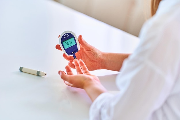 Mujer que usa un medidor de glucosa para medir y controlar el nivel de sangre Atención médica y tratamiento de la diabetes mellitus