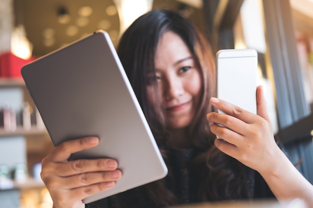 mujer que usa la PC y el teléfono de la tableta