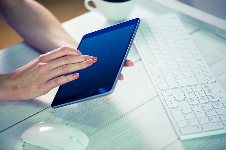 Foto mujer que usa su pc de la tableta en su oficina