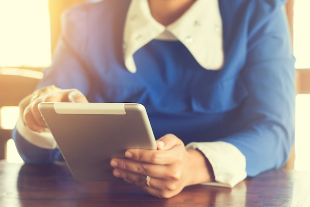 mujer que usa la tableta en el café