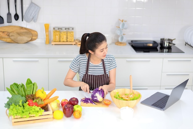 Mujer que usa una tableta para cocinar en su cocina