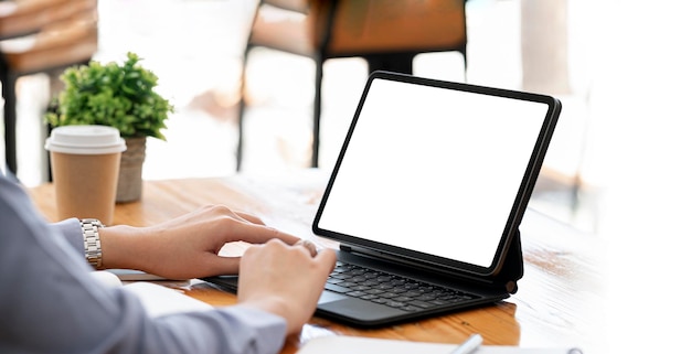 Mujer que usa una tableta digital en la pantalla en blanco de la maqueta de la oficina para mostrar productos o diseño gráfico
