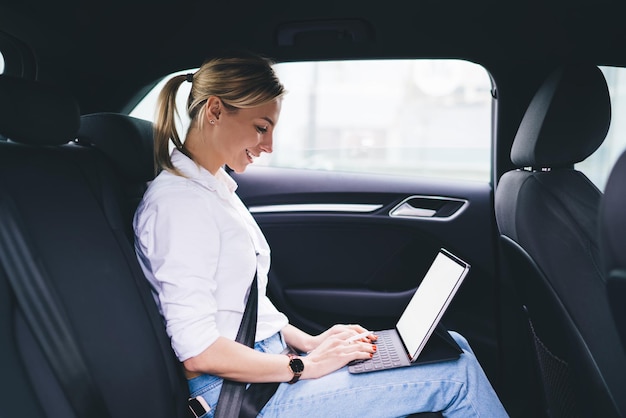 Mujer que usa la tableta mientras está sentado en el coche