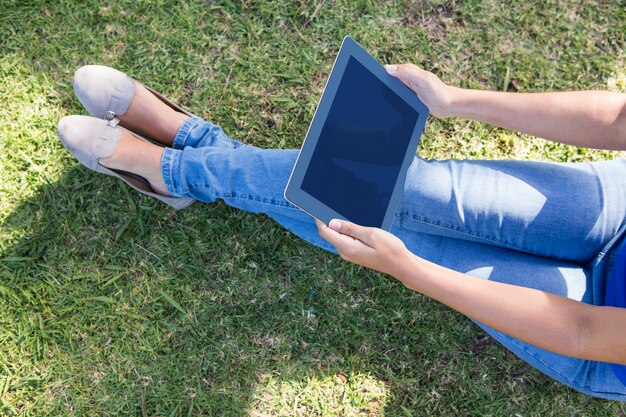 Mujer que usa la tableta en el parque