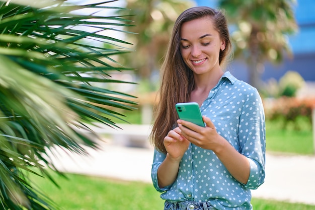 Mujer que usa el teléfono al aire libre en un día soleado