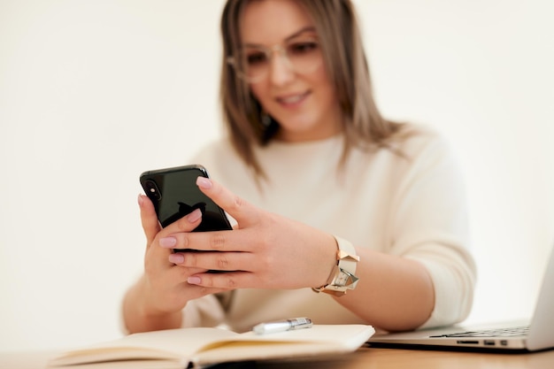 Mujer que usa un teléfono inteligente durante el trabajo remoto