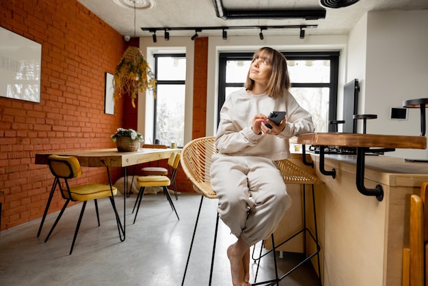 Mujer que usa el teléfono mientras está sentada en un moderno estudio