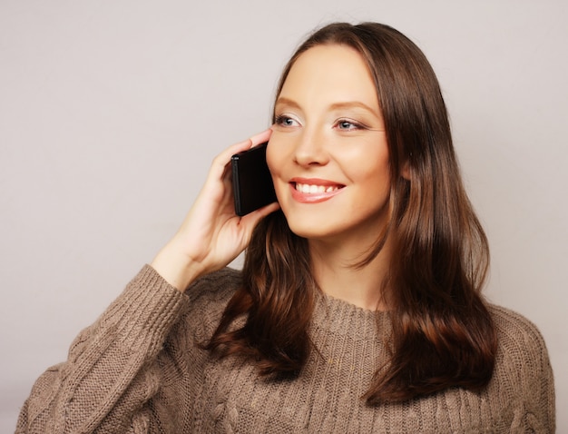 Mujer que usa un teléfono móvil aislado en un blanco