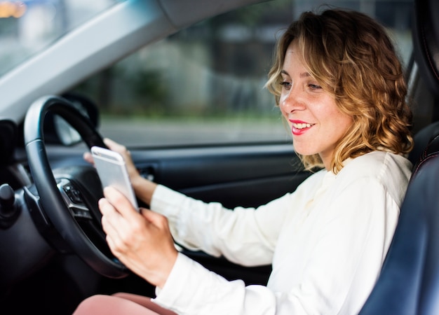 Mujer que usa el teléfono móvil mientras conduce