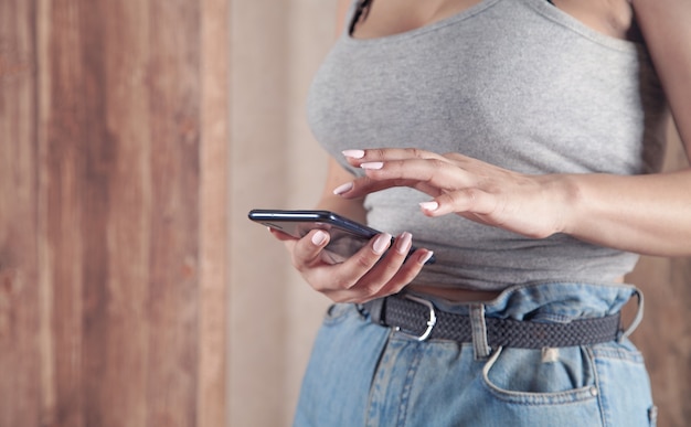 Mujer que usa el teléfono móvil mientras está en casa.