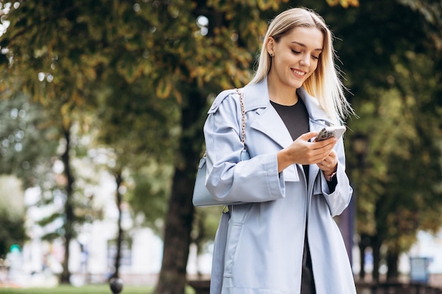 Mujer que usa el teléfono en el parque