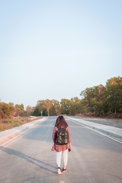 Mujer que viaja con mochila caminando