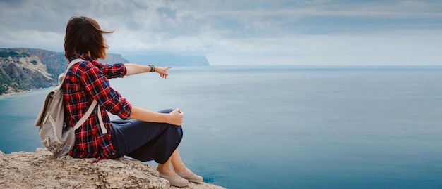 Foto mujer que viaja con mochila turística a orillas del mar en verano