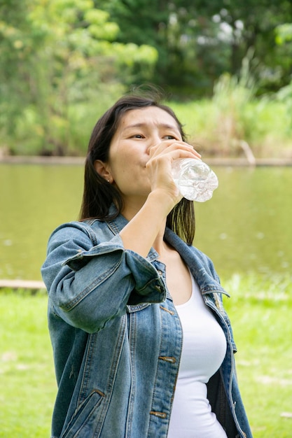 mujer que vive en la naturaleza bebiendo agua