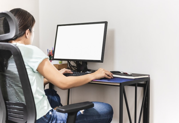 La mujer se queda en casa trabajando en la computadora en casa