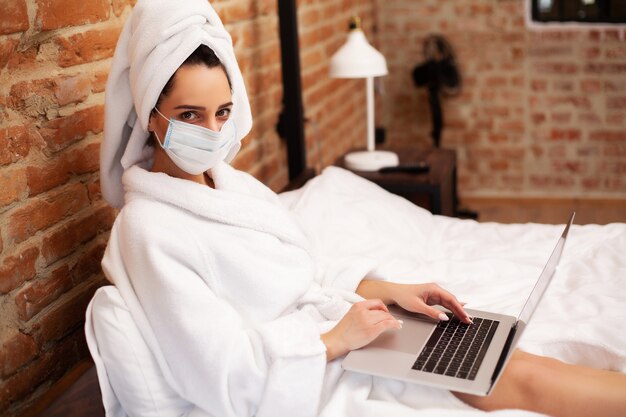 Mujer quedarse en casa durante una epidemia y trabajar en una computadora portátil
