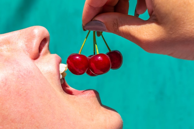 Foto mujer quiere morder una cereza