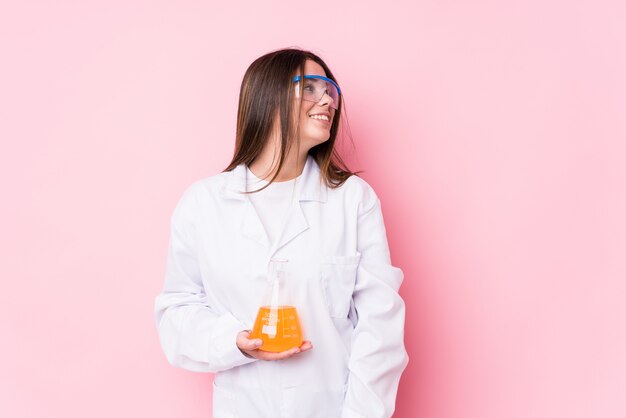 La mujer química joven aislada mira a un lado sonriente, alegre y agradable.