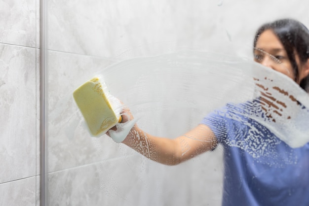 Foto mujer quita manchas de agua dura y depósitos en el baño