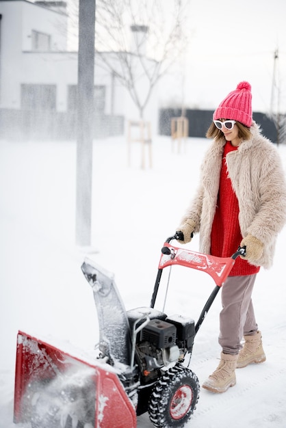 Mujer quita nieve del camino con una máquina quitanieves