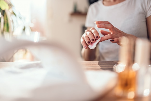 Mujer quitando esmalte de uñas