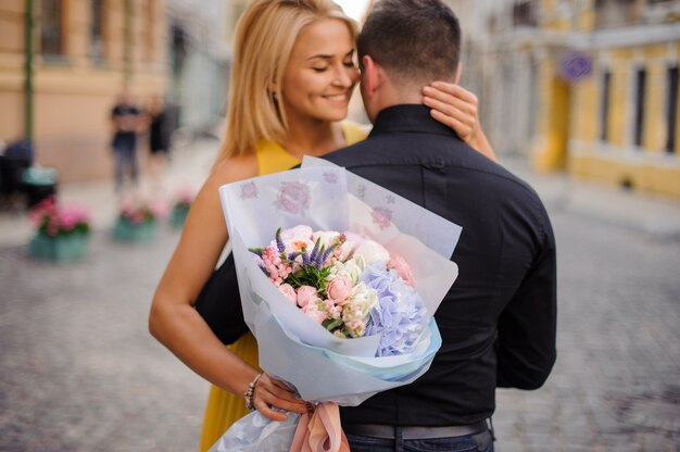 Mujer con un ramo abraza a su novio