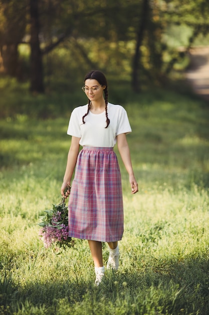 Mujer con ramo de flores al aire libre en el parque de la ciudad