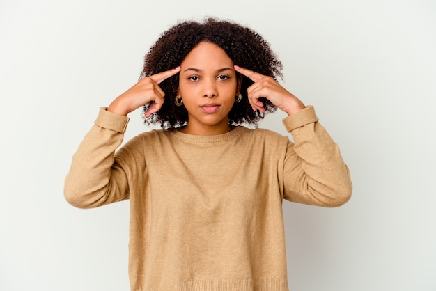 Mujer de raza mixta afroamericana joven aislada se centró en una tarea, manteniendo los dedos índice apuntando la cabeza.