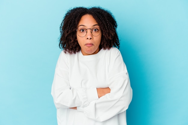 Mujer de raza mixta afroamericana joven aislada sosteniendo algo con palmas, ofreciendo.