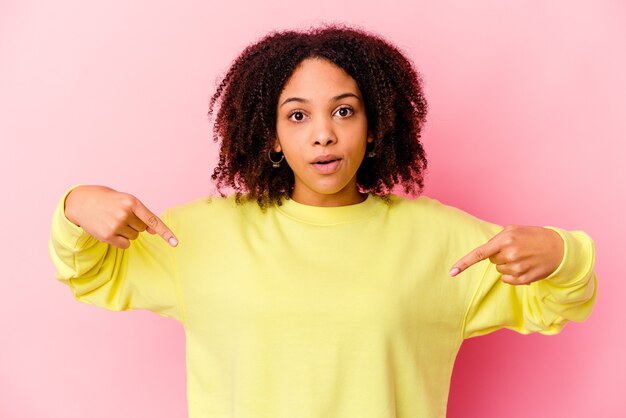 Mujer de raza mixta afroamericana joven aislado apunta hacia abajo con los dedos, sentimiento positivo.