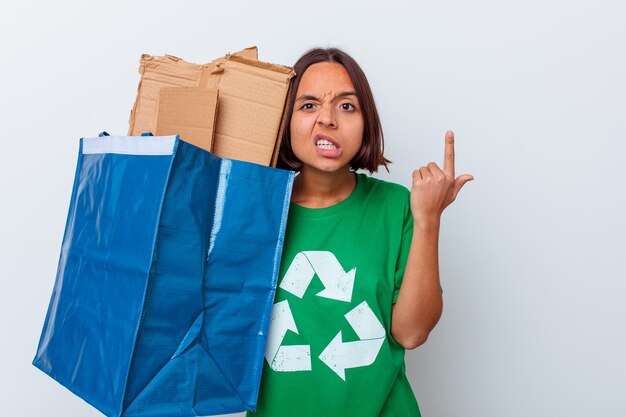 Mujer de raza mixta joven reciclando cartón aislado en la pared blanca que muestra un gesto de decepción con el dedo índice.