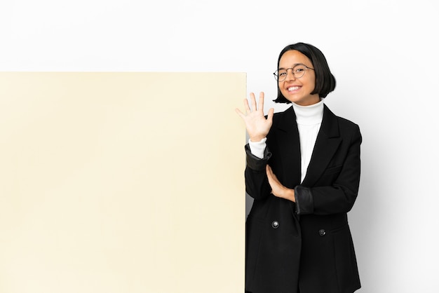 Mujer de raza mixta de negocios joven con una gran pancarta sobre antecedentes aislados contando cinco con los dedos