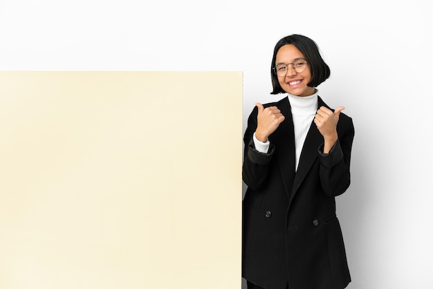 Mujer de raza mixta de negocios joven con una gran pancarta sobre fondo aislado con gesto de pulgar hacia arriba y sonriente
