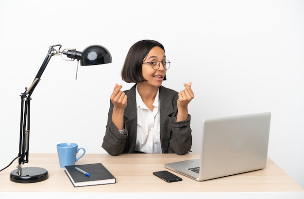 Mujer de raza mixta de negocios joven que trabaja en la oficina haciendo gesto de dinero