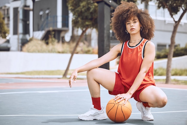 Mujer de raza mixta posando en una cancha de baloncesto. Hermoso jugador de baloncesto posando con confianza afuera.