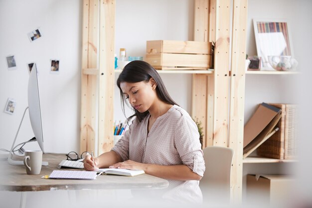 Foto mujer de raza mixta tomando notas