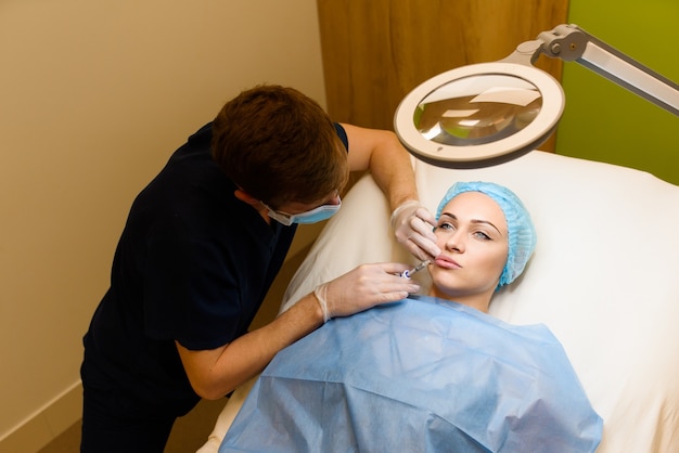 Mujer realiza un procedimiento de inyecciones faciales rejuvenecedoras para el aumento de labios