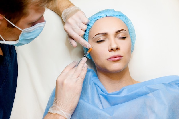 La mujer realiza un procedimiento de inyecciones faciales rejuvenecedoras para tensar y suavizar las arrugas en la esquina del ojo