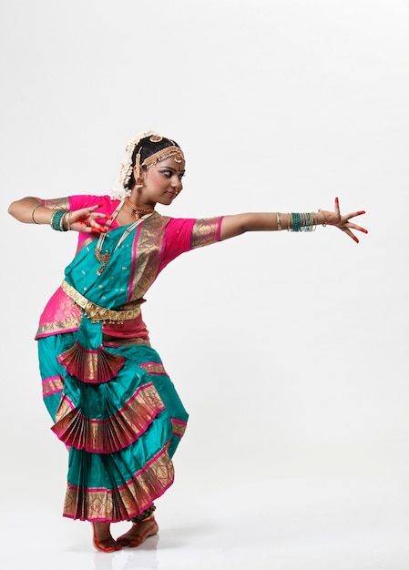 Mujer realizando bharatnatyam contra un fondo blanco