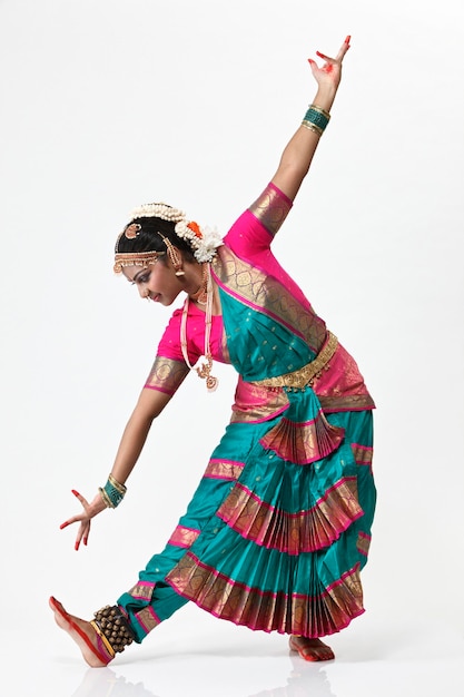 Foto mujer realizando bharatnatyam contra un fondo blanco