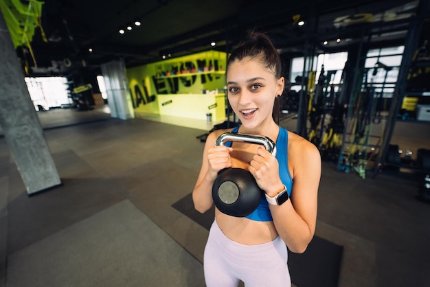 Mujer realizando ejercicio con pesas rusas pesadas mientras hace ejercicio