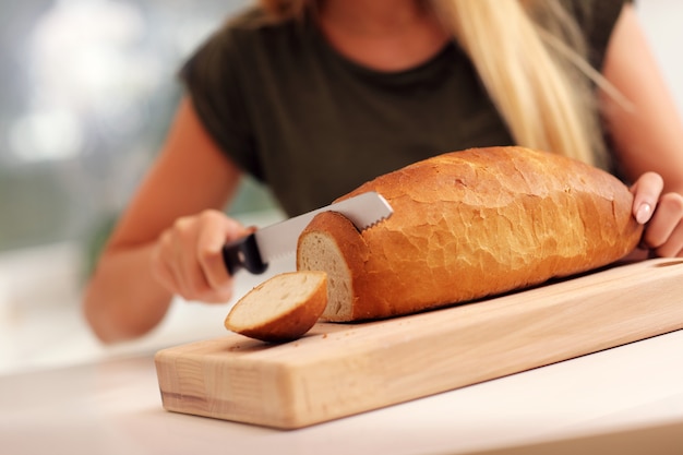 mujer, rebanar, hogaza de pan